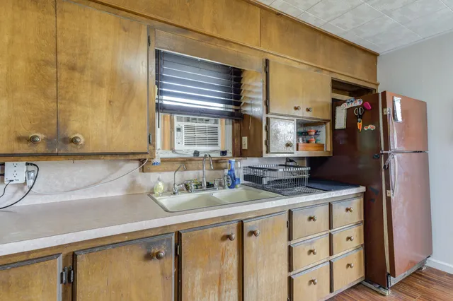a kitchen with stainless steel appliances granite countertop a sink and a refrigerator