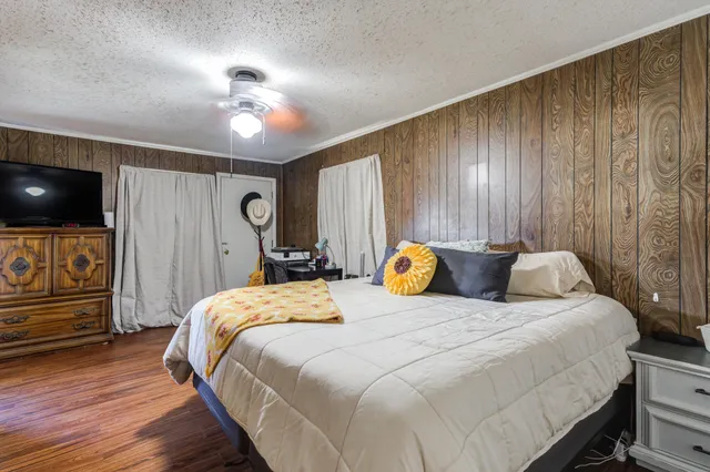 a bedroom with bed and wooden floor