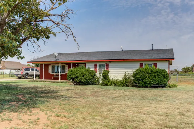 a front view of a house with a yard and potted plants