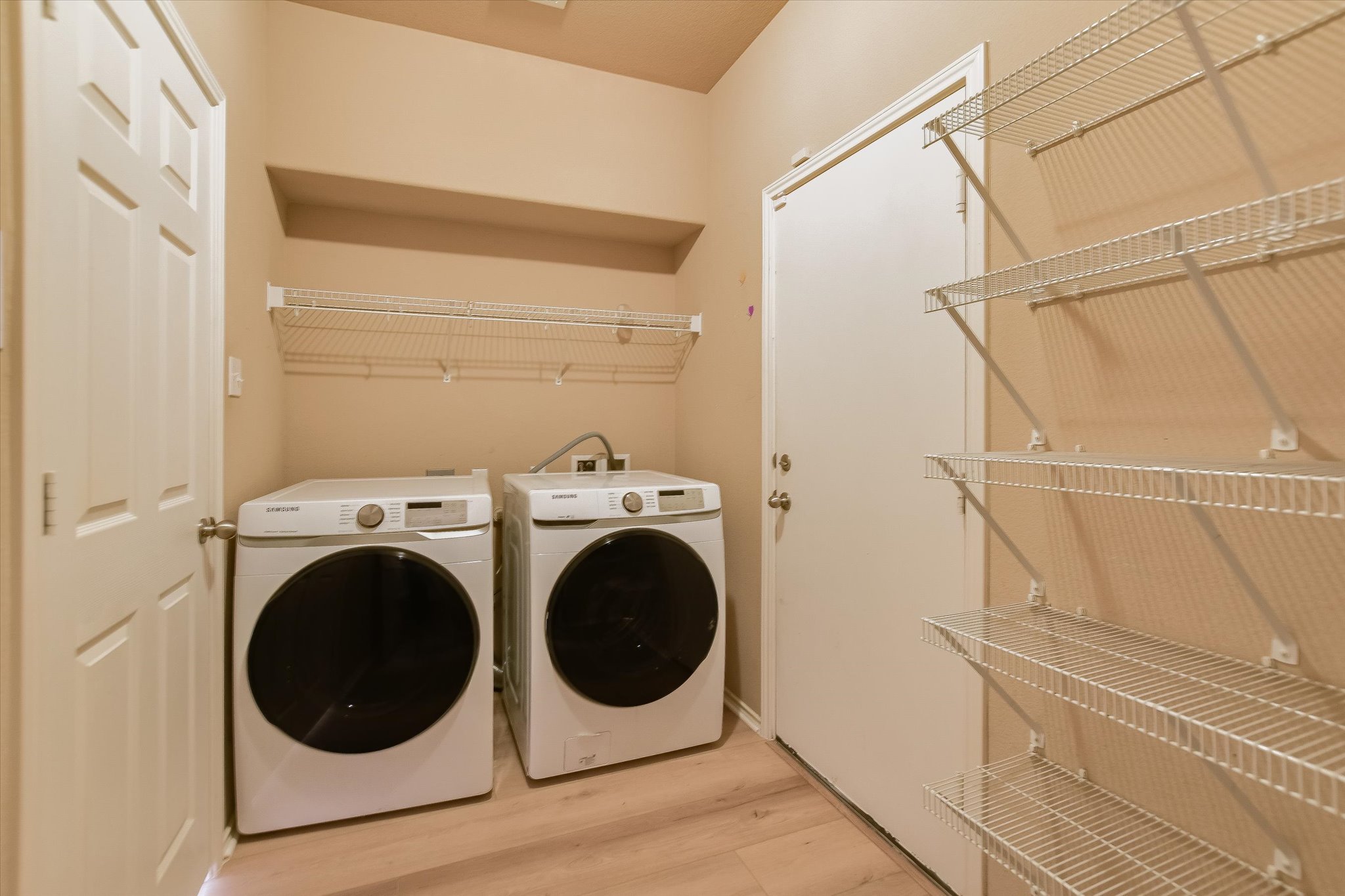 1420 Huckleberry Lane Austin, TX 78748 - Photo 11 of 21 Laundry area featuring light wood-style flooring and separate washer and dryer