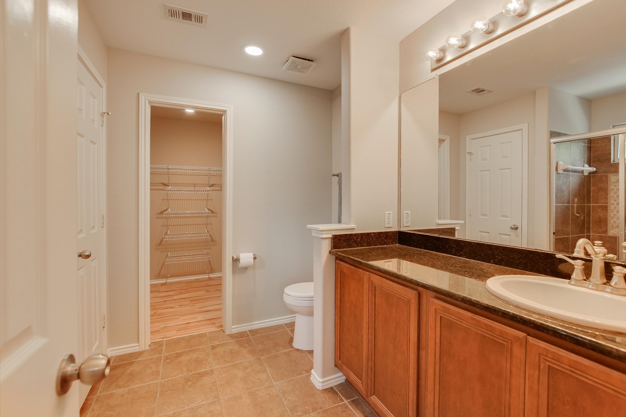 1420 Huckleberry Lane Austin, TX 78748 - Photo 16 of 21 Primary Bathroom featuring vanity, light tile floors, a spacious closet, a walk in shower, and recessed lighting