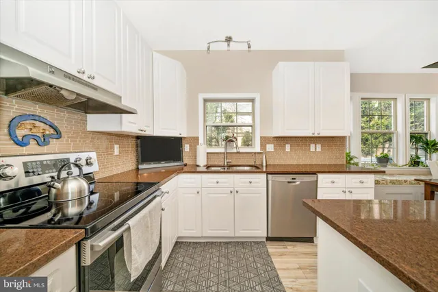 a kitchen with a sink stove top oven and cabinets