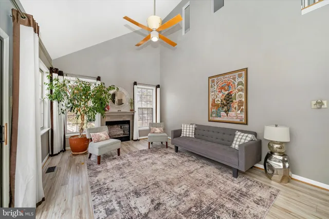a living room with furniture a fireplace and a large window