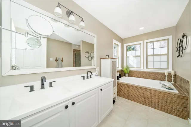 a spacious bathroom with sinks mirror and a bathtub