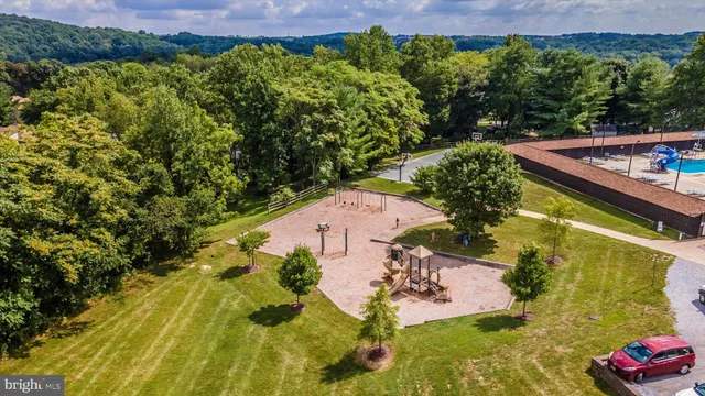 an aerial view of a house with a yard swimming pool and green space