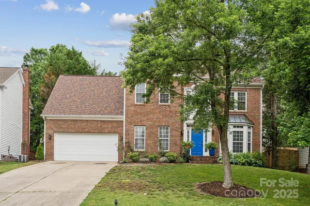 a front view of a house with a yard and trees