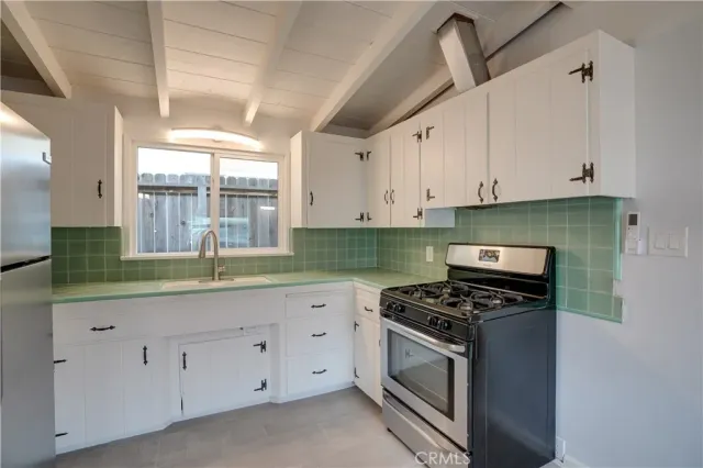 a kitchen with granite countertop white cabinets and white appliances