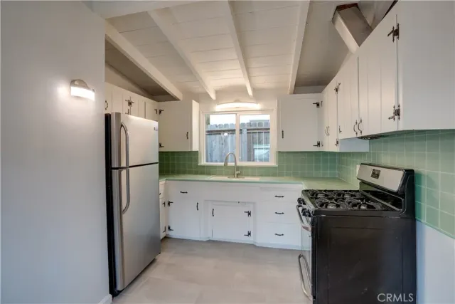 a kitchen with granite countertop a refrigerator and a stove top oven