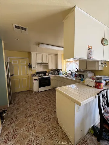 a kitchen with stainless steel appliances granite countertop a stove a sink a refrigerator a microwave and cabinets