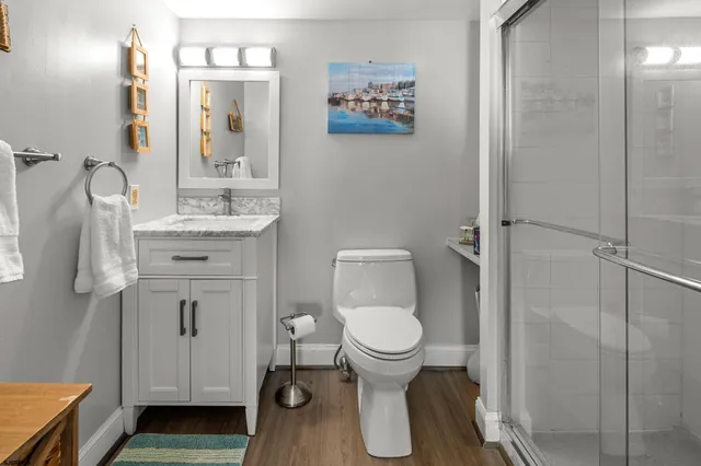 a bathroom with a granite countertop toilet sink and mirror