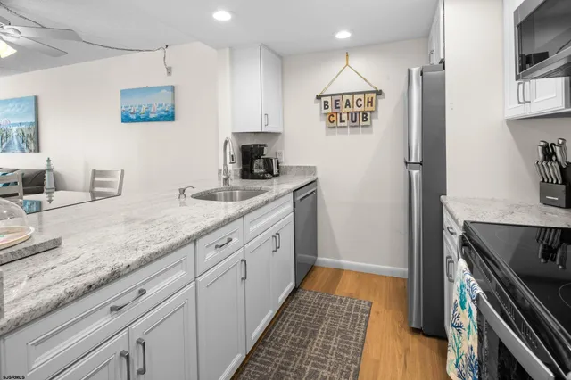 a kitchen with stainless steel appliances granite countertop a refrigerator and a stove top oven