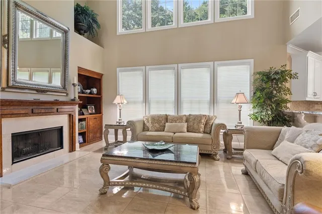 a living room with furniture a large window and a fireplace