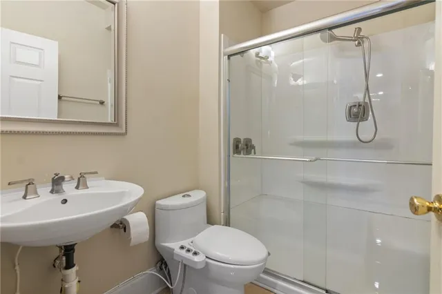 a bathroom with a shower a sink and toilet