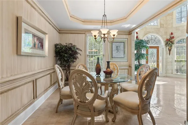 a view of a dining room with furniture a chandelier and wooden floor