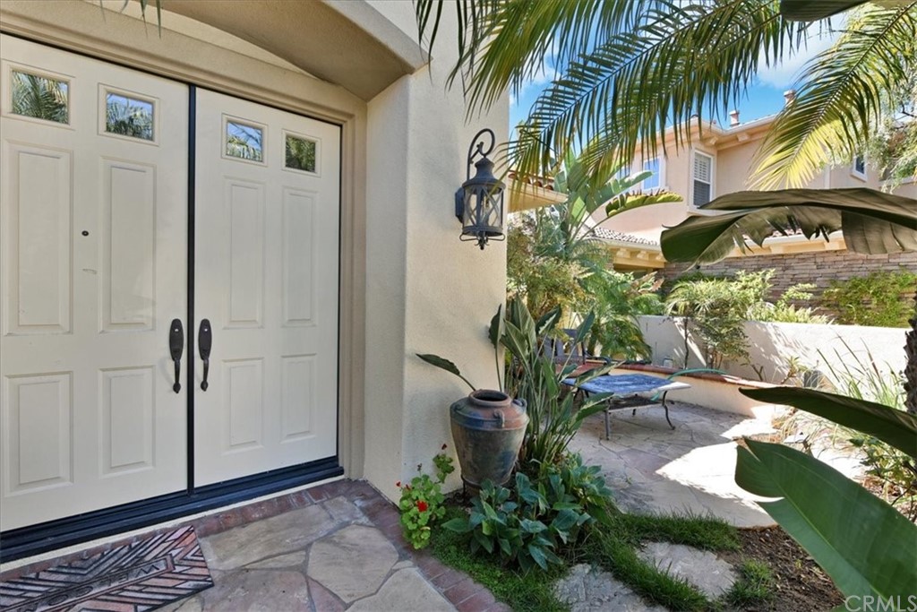 18 Sable Sands Newport Coast, CA 92657 - Photo 4 of 37 a vase of flowers sitting on a floor in front of a door