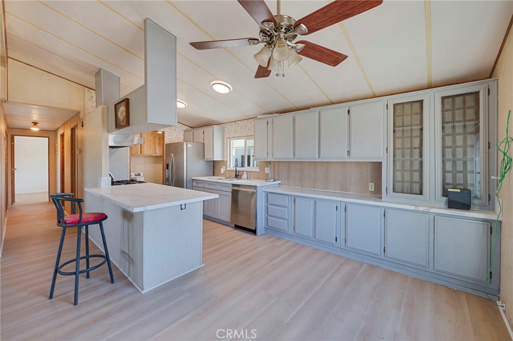 19665 Grey Mountain Road Adelanto, CA 92301 - Photo 20 of 30 a kitchen with stainless steel appliances kitchen island hardwood floor sink and cabinets