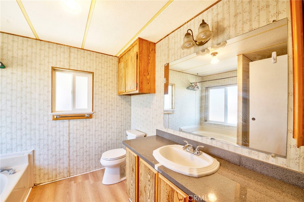 19665 Grey Mountain Road Adelanto, CA 92301 - Photo 23 of 30 a bathroom with a granite countertop sink toilet and mirror