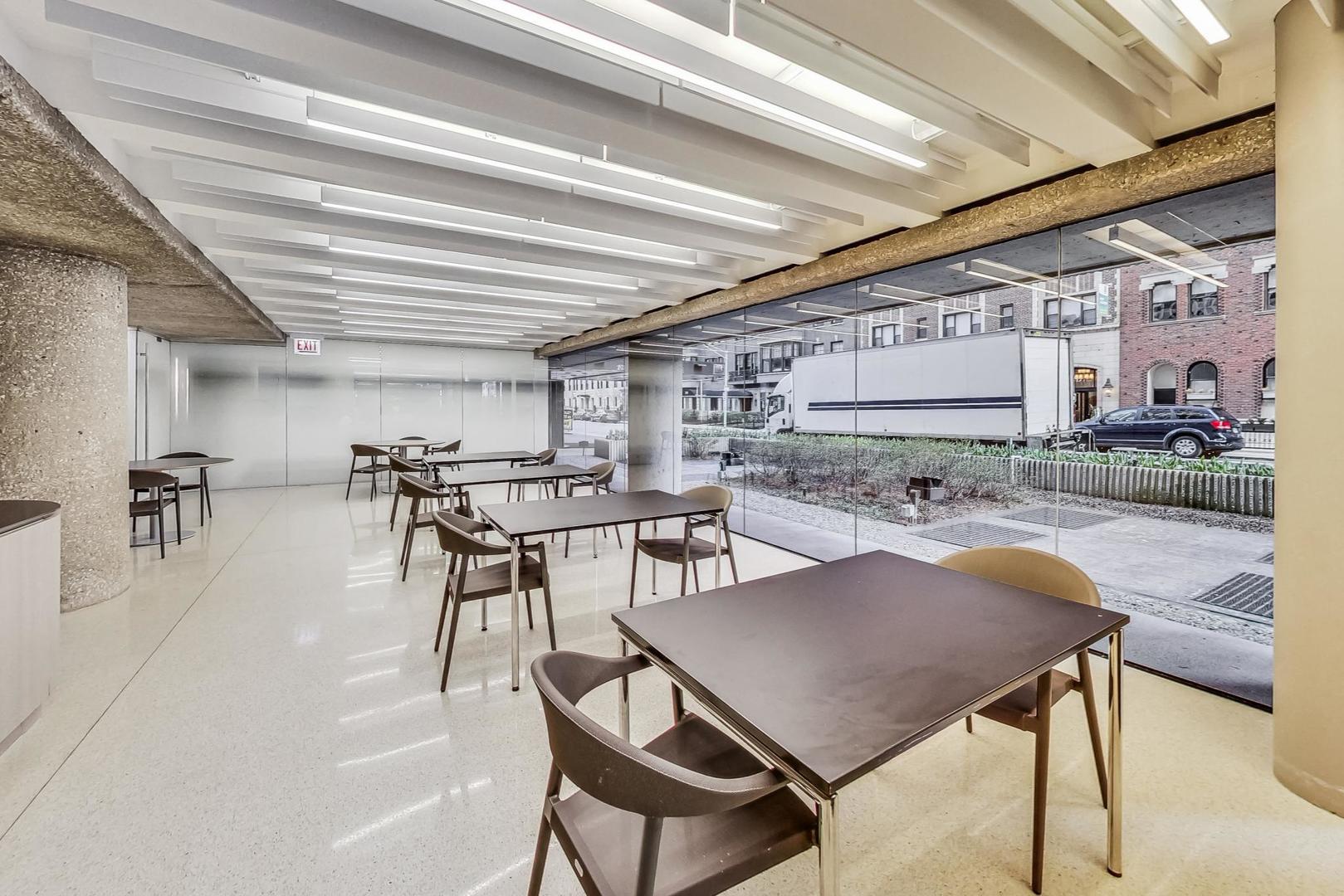 200 East Delaware Place, Unit 18F Chicago, IL 60611 - Photo 37 of 38 a dining hall with stainless steel appliances kitchen island granite countertop a table chairs and a refrigerator