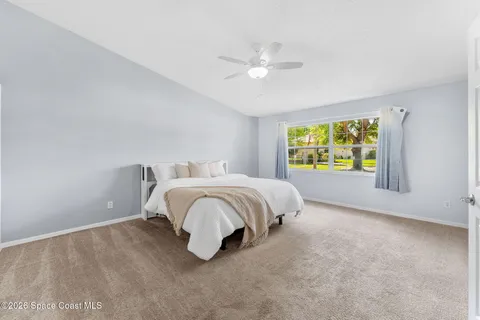 a spacious bedroom with a bed and a window