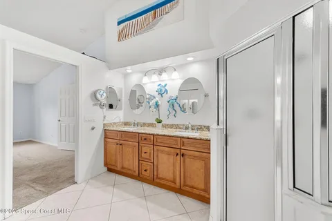 a bathroom with a granite countertop sink a mirror and a shower