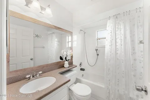 a bathroom with a granite countertop sink a toilet and shower