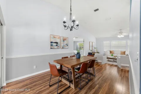 a view of a dining room with furniture wooden floor and a chandelier