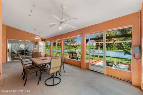 a dining room with furniture water view and a floor to ceiling window