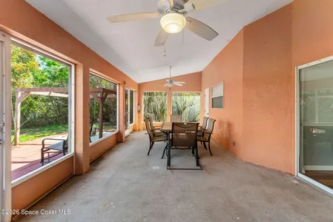 a dining room with furniture a chandelier and large windows