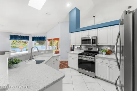 a kitchen with stainless steel appliances granite countertop a sink a stove and a refrigerator