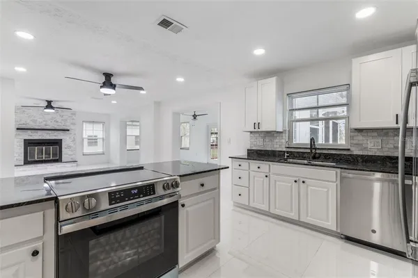 a kitchen with stainless steel appliances granite countertop a stove and a sink