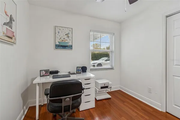 a view of a workspace with furniture and a window
