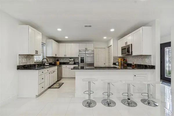 a kitchen with stainless steel appliances granite countertop a sink and cabinets