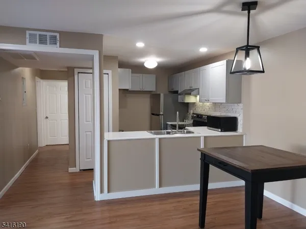 a kitchen with kitchen island a counter space a sink appliances and cabinets