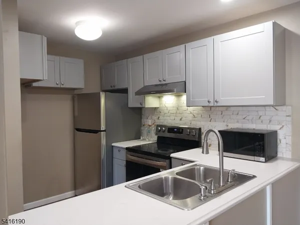 a kitchen with a sink and white cabinets