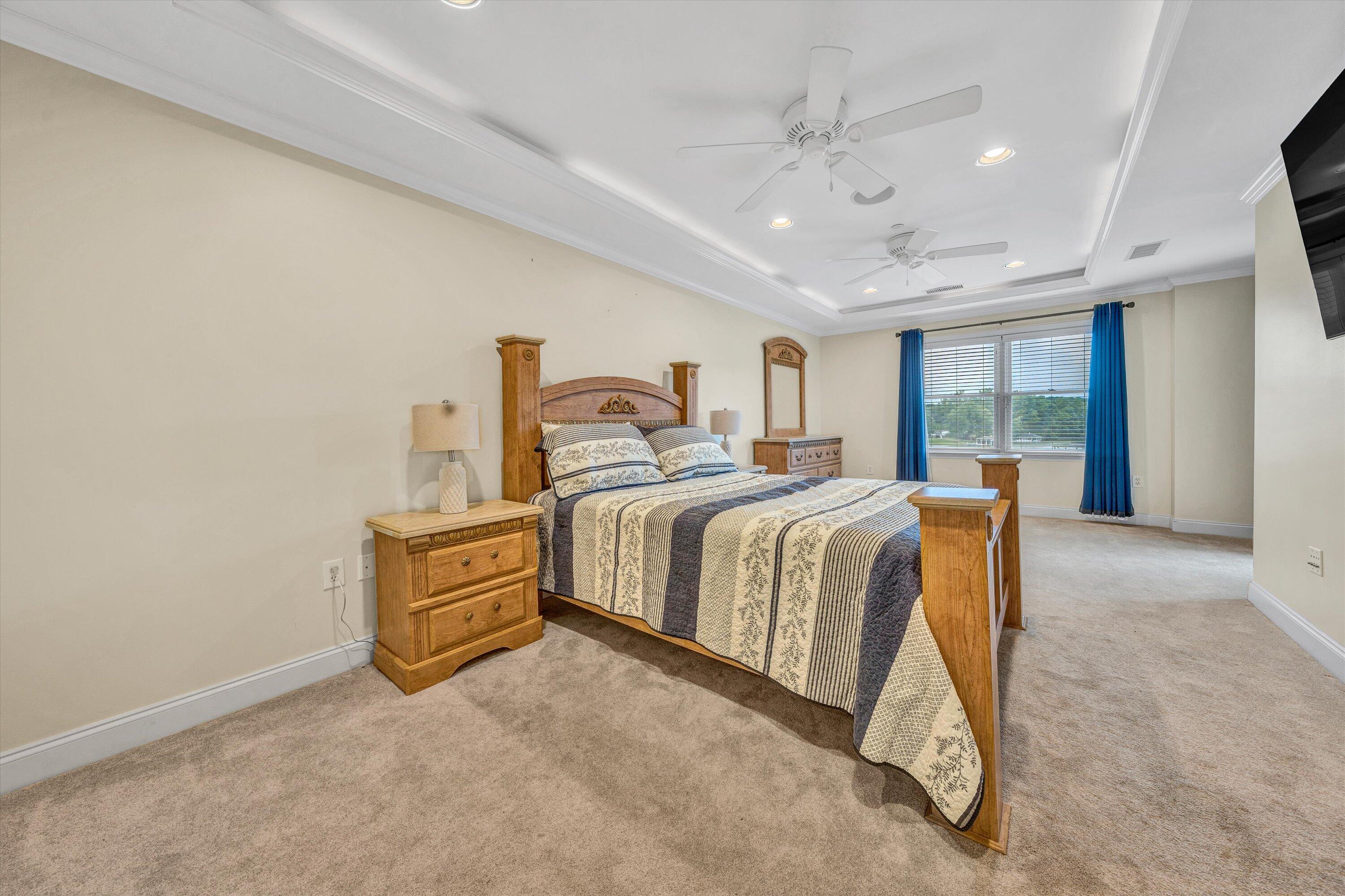 100 Bridgewater Pointe Place, Unit 401 Moneta, VA 24121 - Photo 17 of 39 a spacious bedroom with a bed and a chandelier