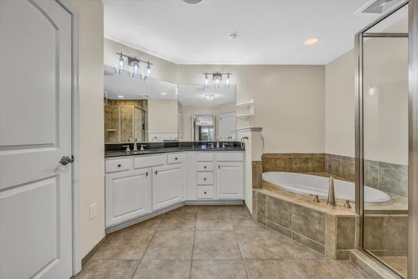 a bathroom with a sink a large mirror and a bathtub