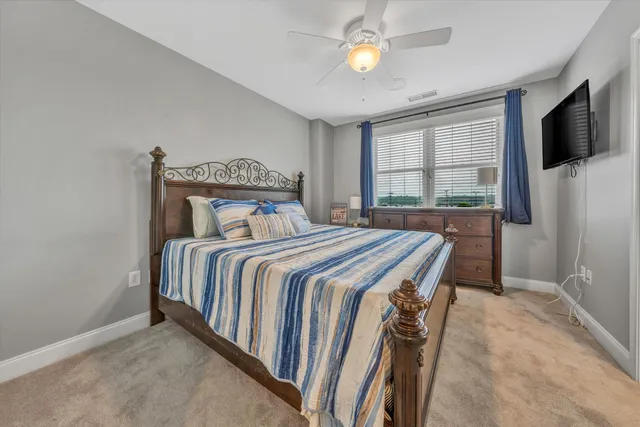 a bedroom with a bed and a flat tv screen on the dresser