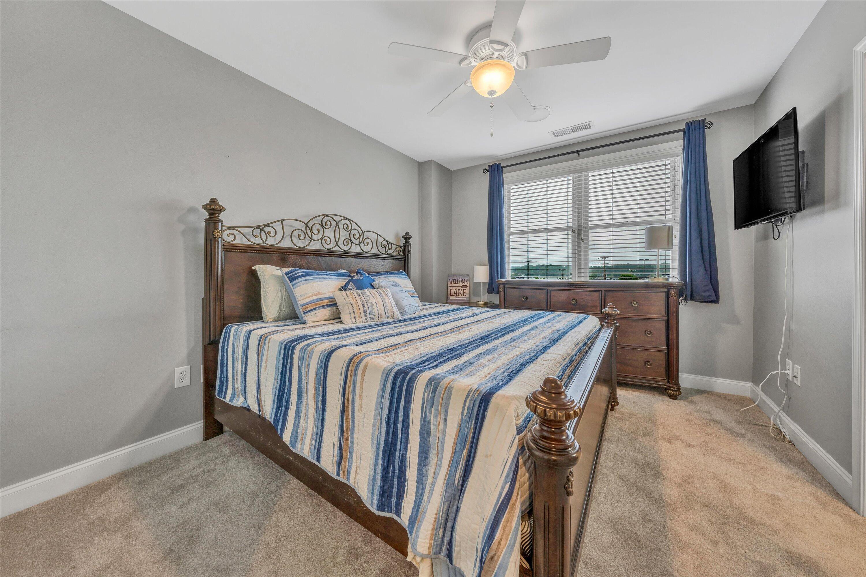 100 Bridgewater Pointe Place, Unit 401 Moneta, VA 24121 - Photo 29 of 39 a bedroom with a bed and a flat tv screen on the dresser