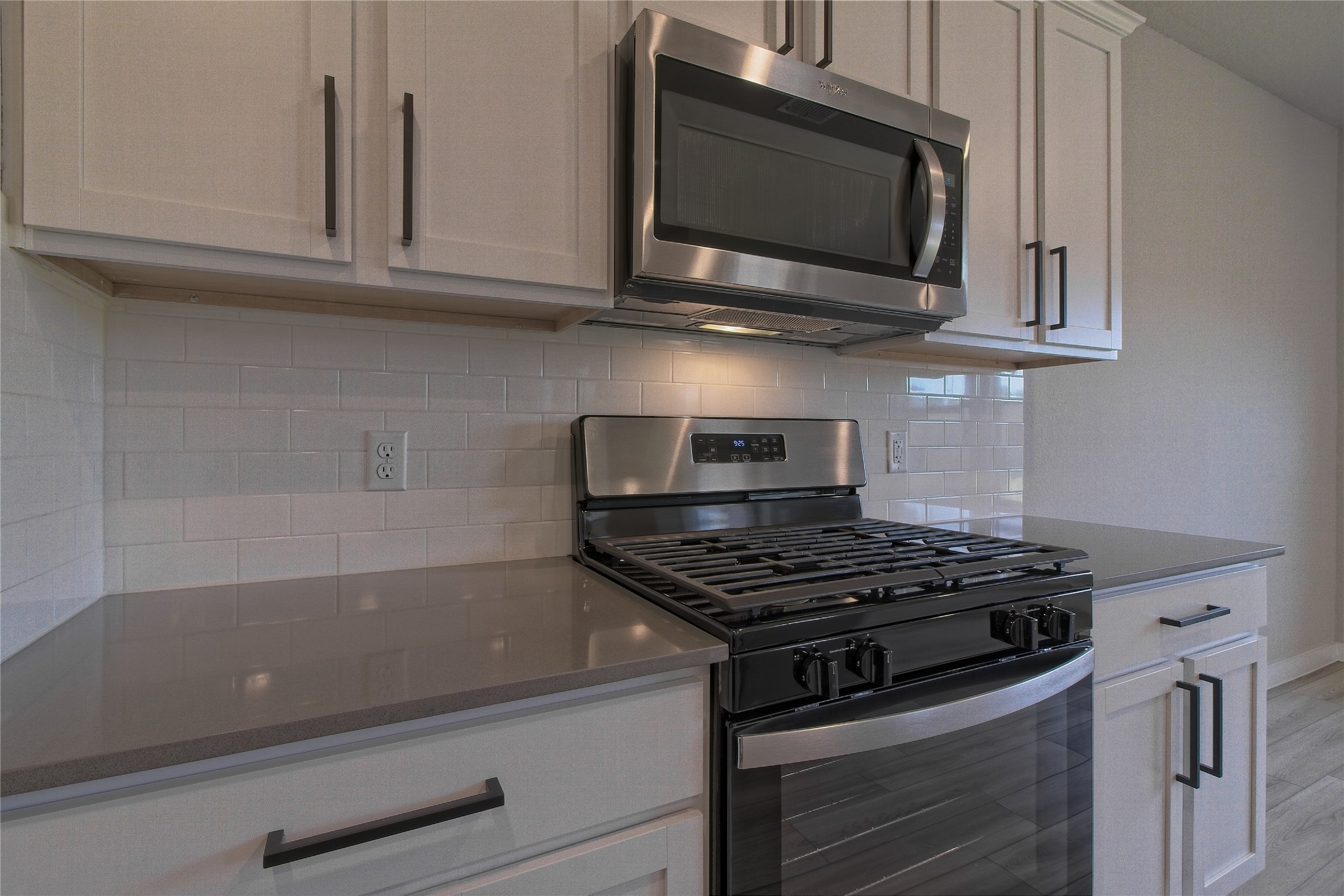 425 Coda Crossing Georgetown, TX 78633 - Photo 11 of 36 Kitchen with stainless steel appliances, tasteful backsplash, dark stone counters, white cabinetry, and light wood-type flooring