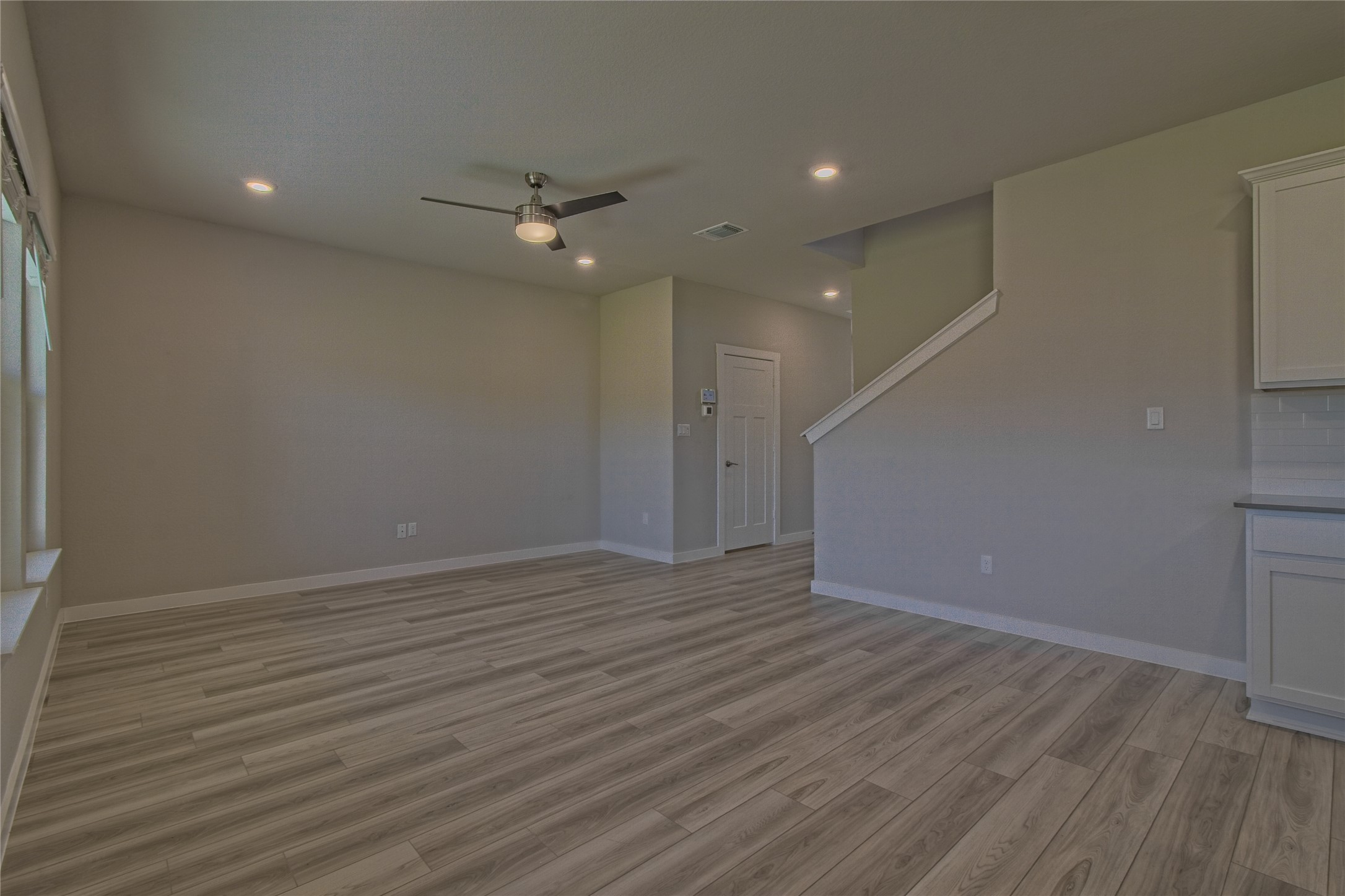 425 Coda Crossing Georgetown, TX 78633 - Photo 9 of 36 Unfurnished living room featuring ceiling fan, light wood finished floors, and recessed lighting