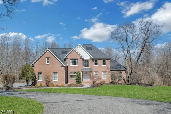 a front view of a house with a garden and trees