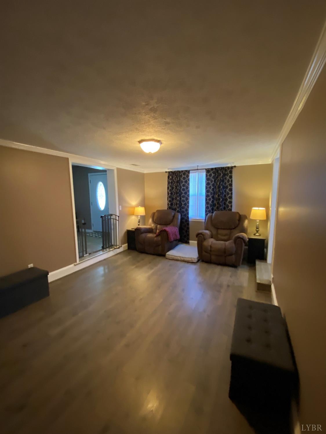 793 Clover Road Hurt, VA 24563 - Photo 13 of 19 a living room with furniture a fireplace and gym equipment