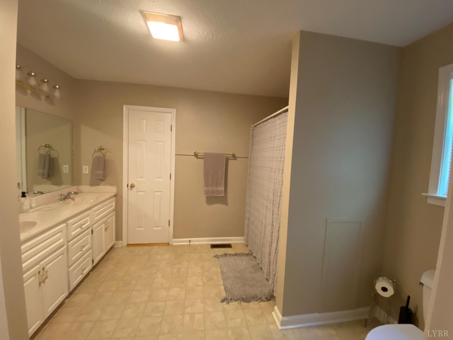793 Clover Road Hurt, VA 24563 - Photo 19 of 19 a bathroom with a granite countertop sink mirror and a bathtub