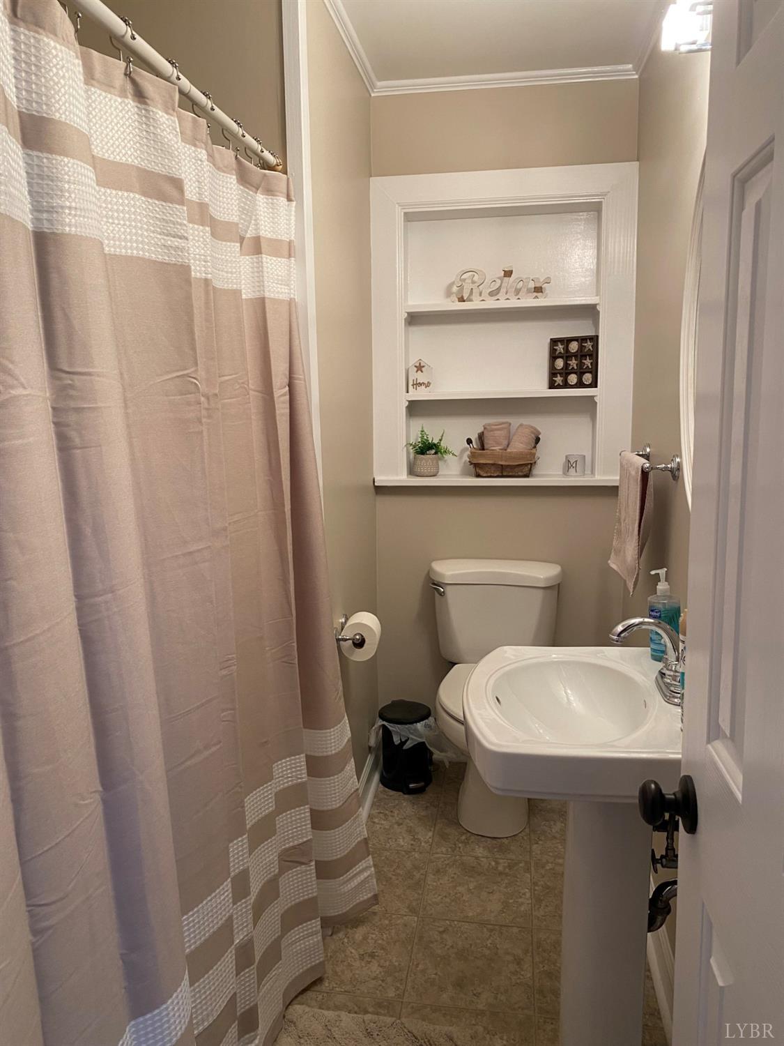 793 Clover Road Hurt, VA 24563 - Photo 9 of 19 a bathroom with a sink a toilet and shower curtain