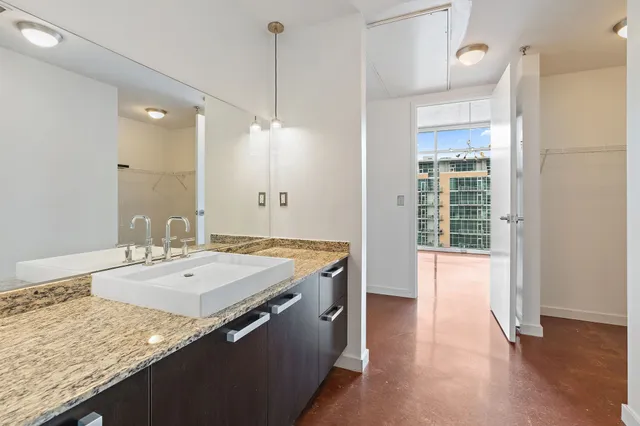 a bathroom with a granite countertop sink a large mirror and a shower