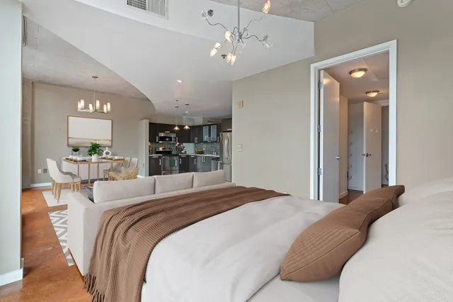 a bedroom with a large bed and a chandelier