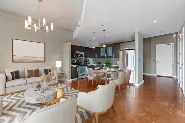 a living room with furniture kitchen and a chandelier