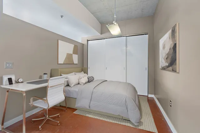 a bedroom with a bed and a table chair