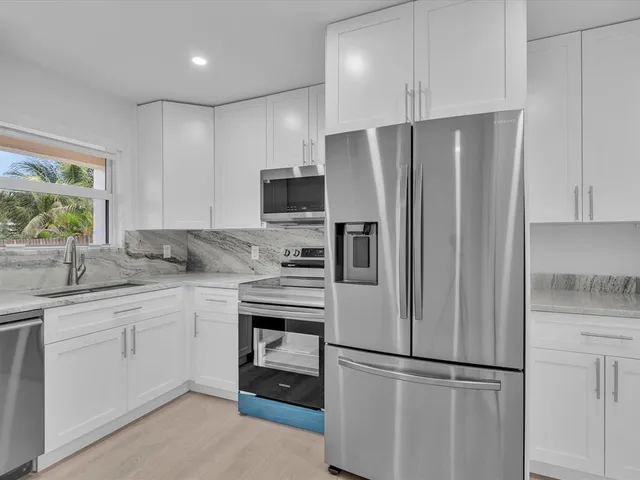 a kitchen with stainless steel appliances a refrigerator sink and microwave