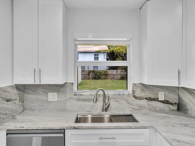 a kitchen with a sink cabinets and window
